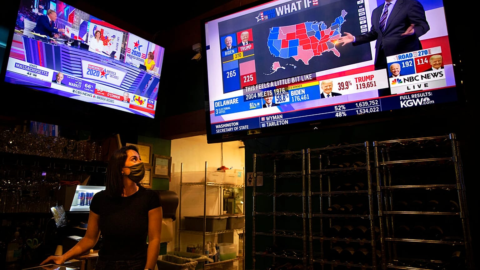 Bartender Sam Schilke watches election results on television at a bar and grill Tuesday, Nov. 3, 2020, in Portland, Ore. (AP Photo/Paula Bronstein)