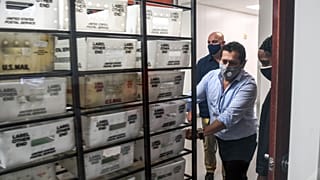 Electoral workers are seen during the vote-by-mail ballot scanning process