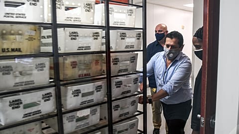 Electoral workers are seen during the vote-by-mail ballot scanning process