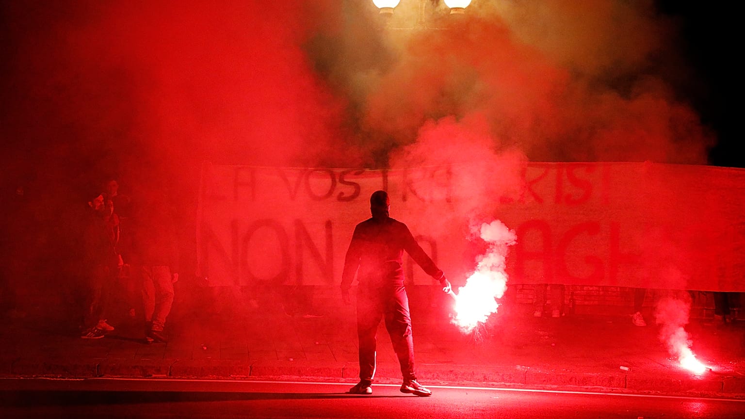 Demonstrators brandish flares and a banner during a protest against restriction measures imposed to curb the spread of COVID-19. Naples, Italy, Oct. 31, 2020