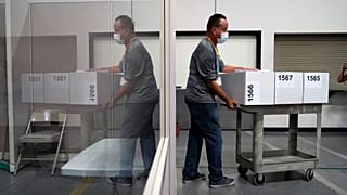 A county election worker moves boxes of counted ballots at a tabulating area at the Clark County Election Department in Las Vegas, Nevada.