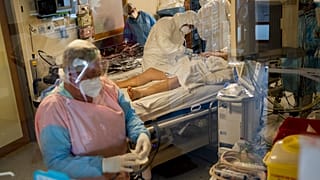 Medical personnel wearing protective equipment work with a coronavirus patient who will be transferred by helicopter from the COVID-19 intensive care unit of the CHU Liege hos