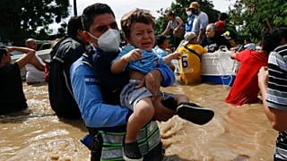 Un niño es socorrido por los equipos de rescate en Honduras