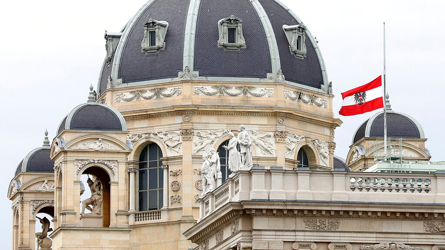 The Austrian national flag waves of half-mast on a building downtown in Vienna, Austria, Wednesday, Nov. 4, 2020.