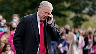 White House chief of staff Mark Meadows speaks on a phone on the South Lawn of the White House.