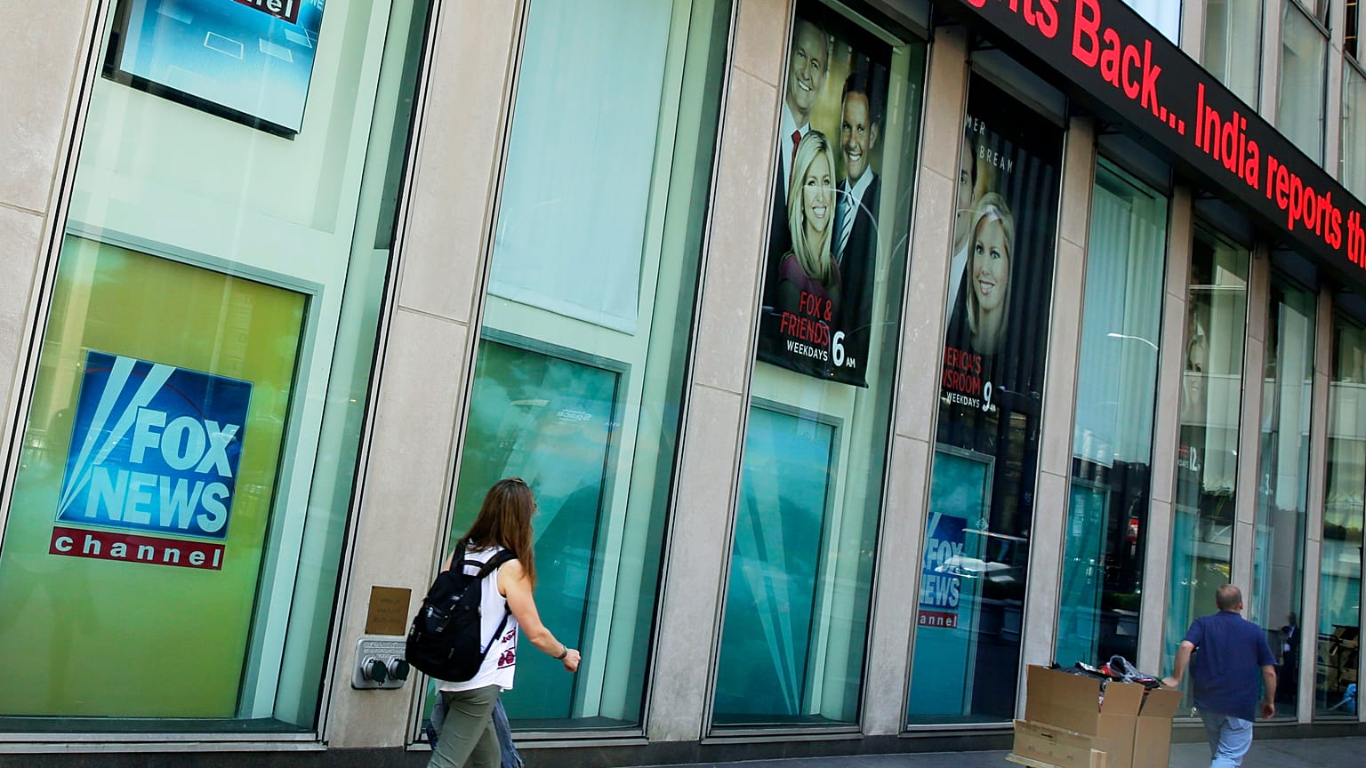 People pass the News Corporation headquarters building and Fox News studios in New York on Aug. 1, 2017. 