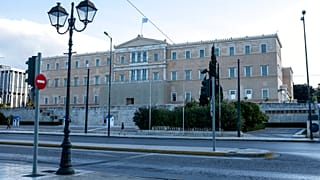 A woman walks in front of the Greek parliamen
