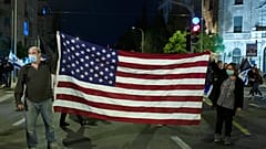 Manifestantes israelitas seguram bandeira dos EUA após vitória de Biden
