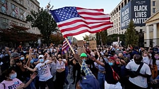 Des Américains rassemblés sur Black Lives Matter Plaza en face de la Maison Blanche à Washington fêtent la victoire de Joe Biden, 8 novembre 2020