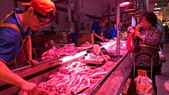 FILE - Sept. 11, 2019, a clerk stacks cuts of pork at a meat market in Beijing. 