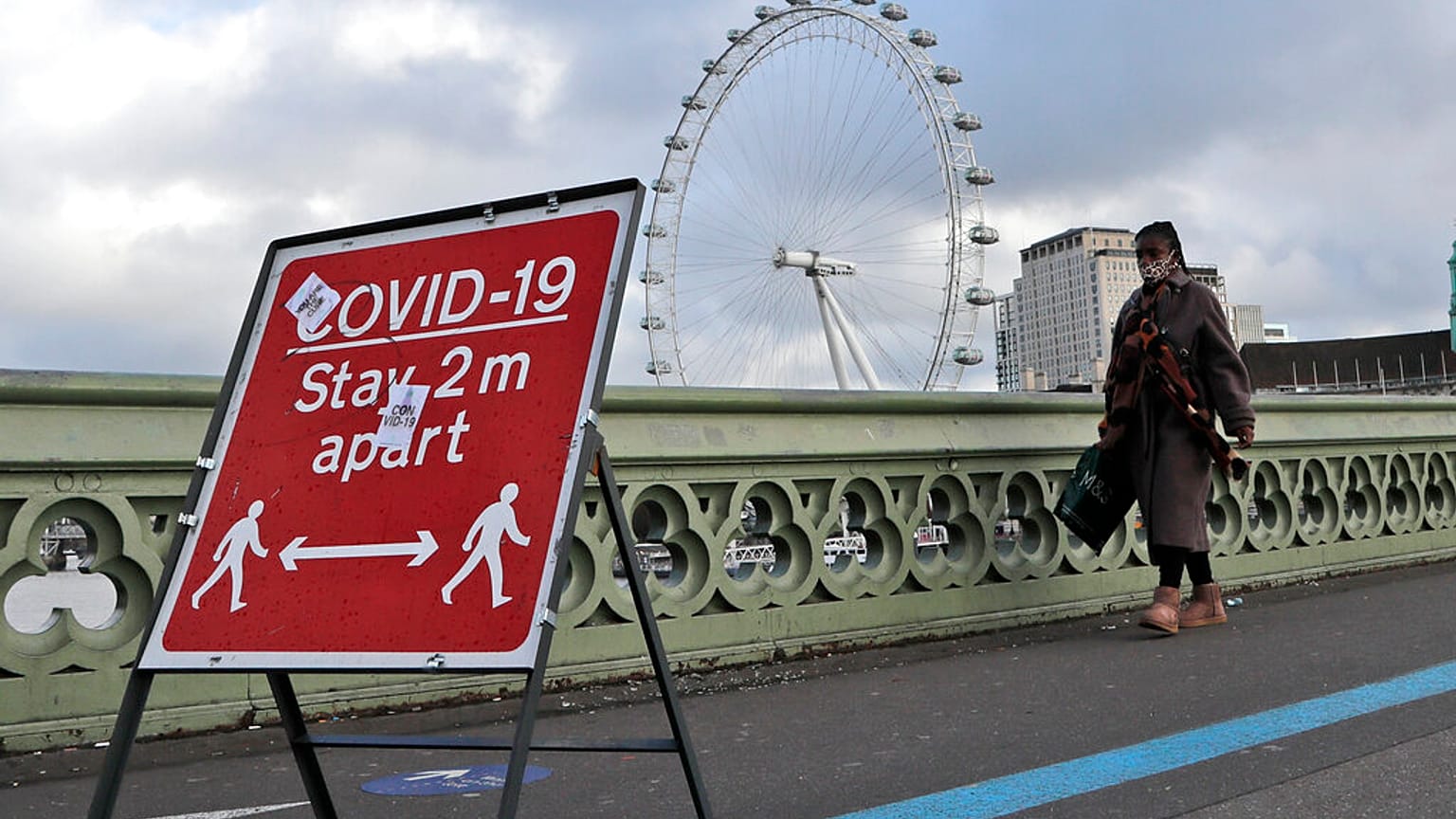 A woman walks over Westminster Bridge during the second coronavirus lockdown in London, Tuesday, Nov. 10, 2020