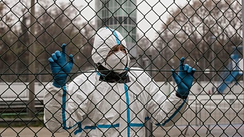 A medical staffer wearing a protective suit waits at a triage check point that was set to ease the pressure on hospitals, following the surge of COVID-19 in Italy.