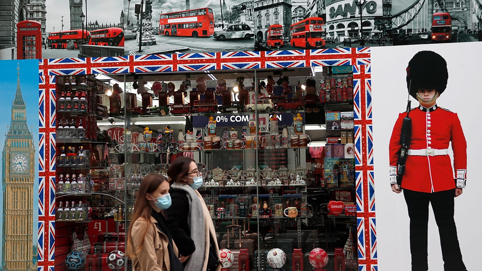 Shoppers walk past a shop window in Oxford Street, London, Tuesday, Oct. 13, 2020. 