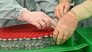 القوارير المغطاة كجزء من اختبارات التعبئة والتغليف للإنتاج على نطاق واسع وتوريد لقاح كوفيد-19.