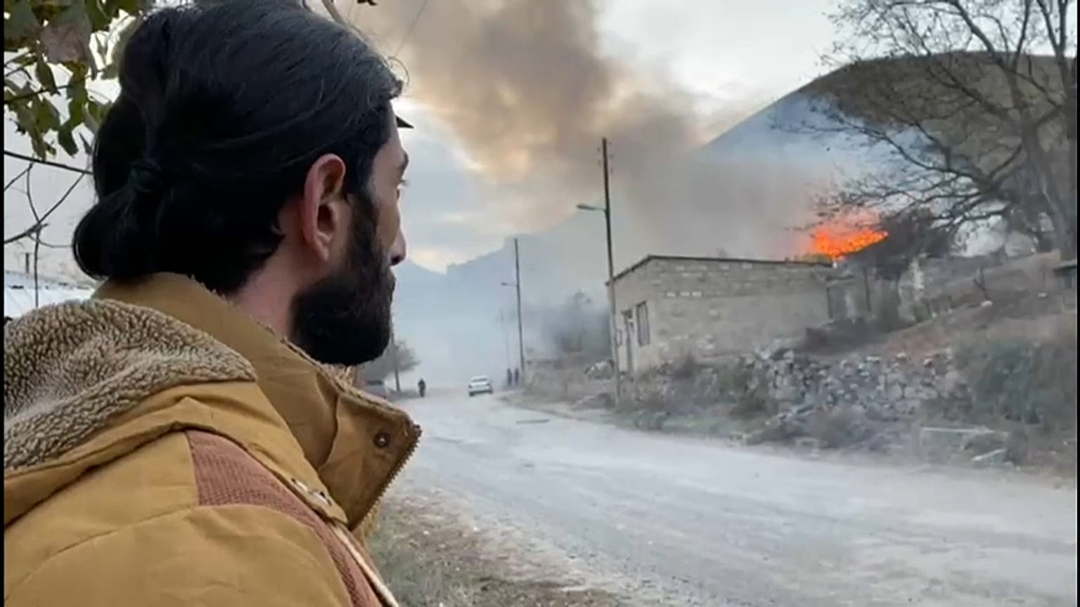 A resident in the town of Karvachar watches his home burn after setting it on fire