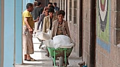 In this Aug. 25, 2019, file photo, displaced Yemenis receive food supplies provided by the World Food Programme, at a school in Sanaa, Yemen. 