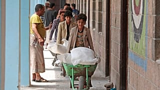 In this Aug. 25, 2019, file photo, displaced Yemenis receive food supplies provided by the World Food Programme, at a school in Sanaa, Yemen. 