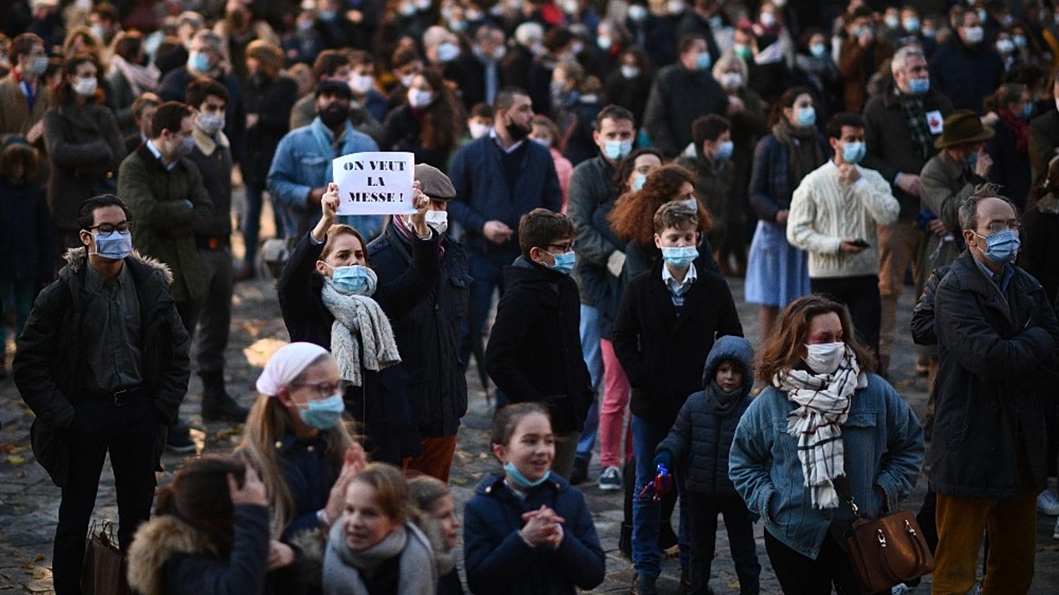 Una donna tiene in mano un cartello con la scritta "Vogliamo la messa", durante una protesta dei fedeli cattolici a Versailles, Francia