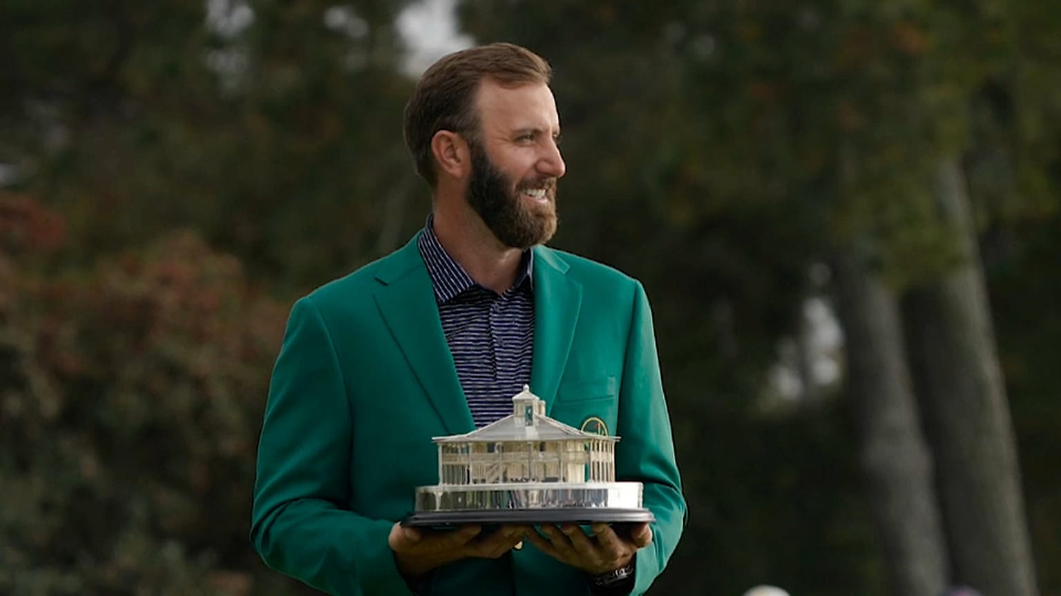 Dustin Johnson, trophée en mains et veste verte sur les épaules