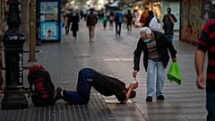 Un passant donne de l'argent à un mendiant sur les Remblas à Barcelone, le 12 novembre 2020
