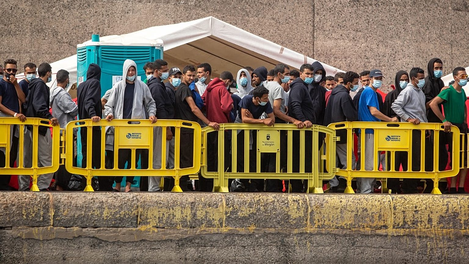 Migrants from a group of 1300 rescued from different boats remain in the port of Arguineguin while being cared for by the Spanish Red Cross