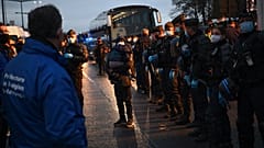 Migrants wait to be evacuated by Gendarmerie forces at a makeshift camp set below the motorway in Saint-Denis, France, on Nov. 17, 2020.