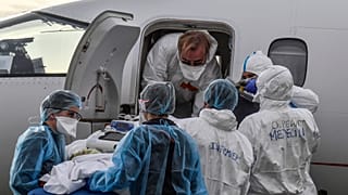 Medical staff load a patient affected with COVID-19 aboard a medical plane at Bron airport near Lyon, central France, Monday, Nov. 16, 2020.
