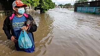 Un residente está parado en una calle inundada de agua en el vecindario de Planeta, Honduras, el 5 de noviembre de 2020.