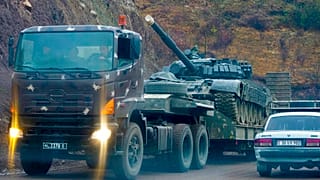 A truck carries an Armenian tank during the withdrawal of Armenian troops near the border between Nagorno-Karabakh and Armenia, Friday, Nov. 13, 2020.
