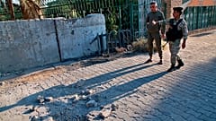 Security forces inspect the scene of the rocket attack at the gate of al-Zawra public park in Baghdad, Iraq, Wednesday, Nov. 18, 2020.