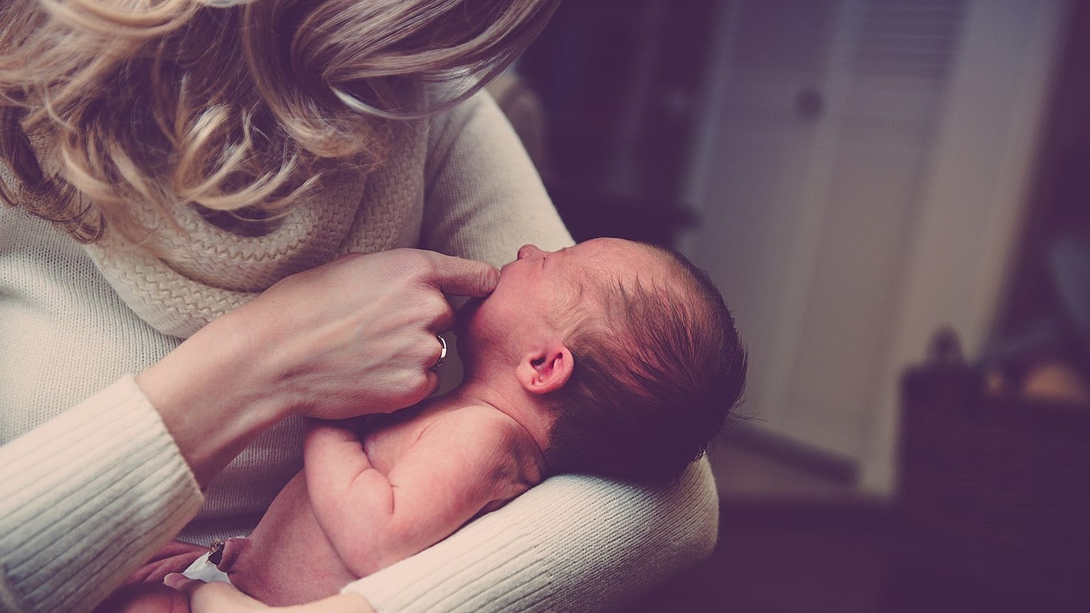 A woman holds a newborn baby.