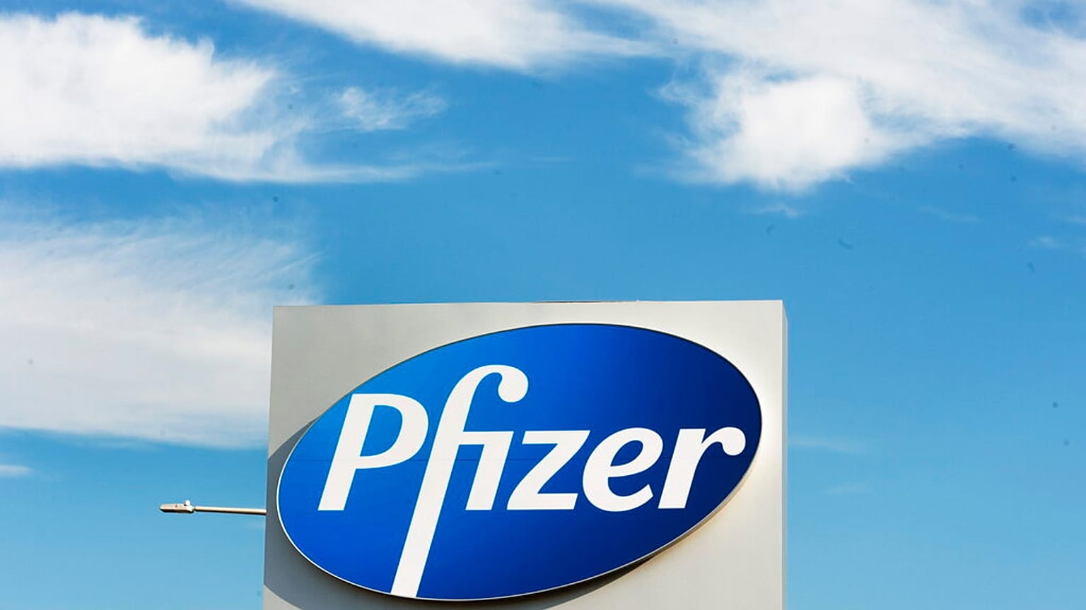  a sign with the Pfizer logo stands outside the corporate headquarters of Pfizer Canada in Montreal.