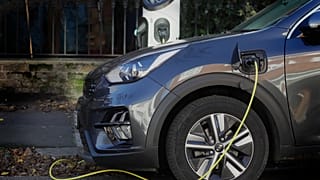 An electric car charges on a street charging port in London