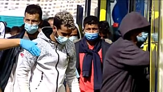 Un grupo de migrantes de Arguineguín sube a un autobús para su traslado a Barranco Seco