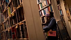 A woman wears a face mask, to protect against the spread of coronavirus, as she browses for books in a second-hand bookshop in Brussels, June 11, 2020.