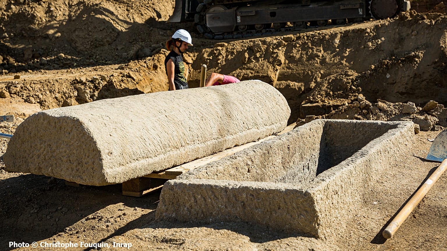 Sarcophage en pierre ouvert, le couvercle est posé à côté de la cuve