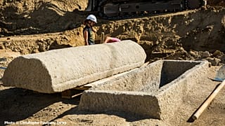 Sarcophage en pierre ouvert, le couvercle est posé à côté de la cuve