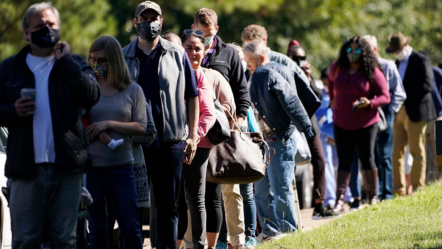 Voters brave a bright sun as they wait to cast their ballots in Mississippi, US.