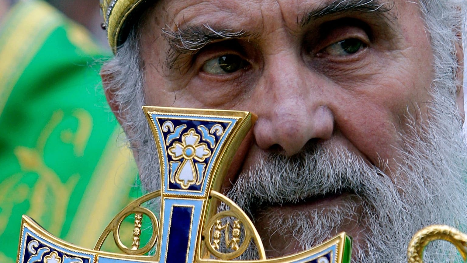 In this May 24, 2012, file photo, Serbian Orthodox Church Patriarch Irinej holds a cross during a procession marking Belgrade's patrons saint day, Spasovdan, in Belgrade