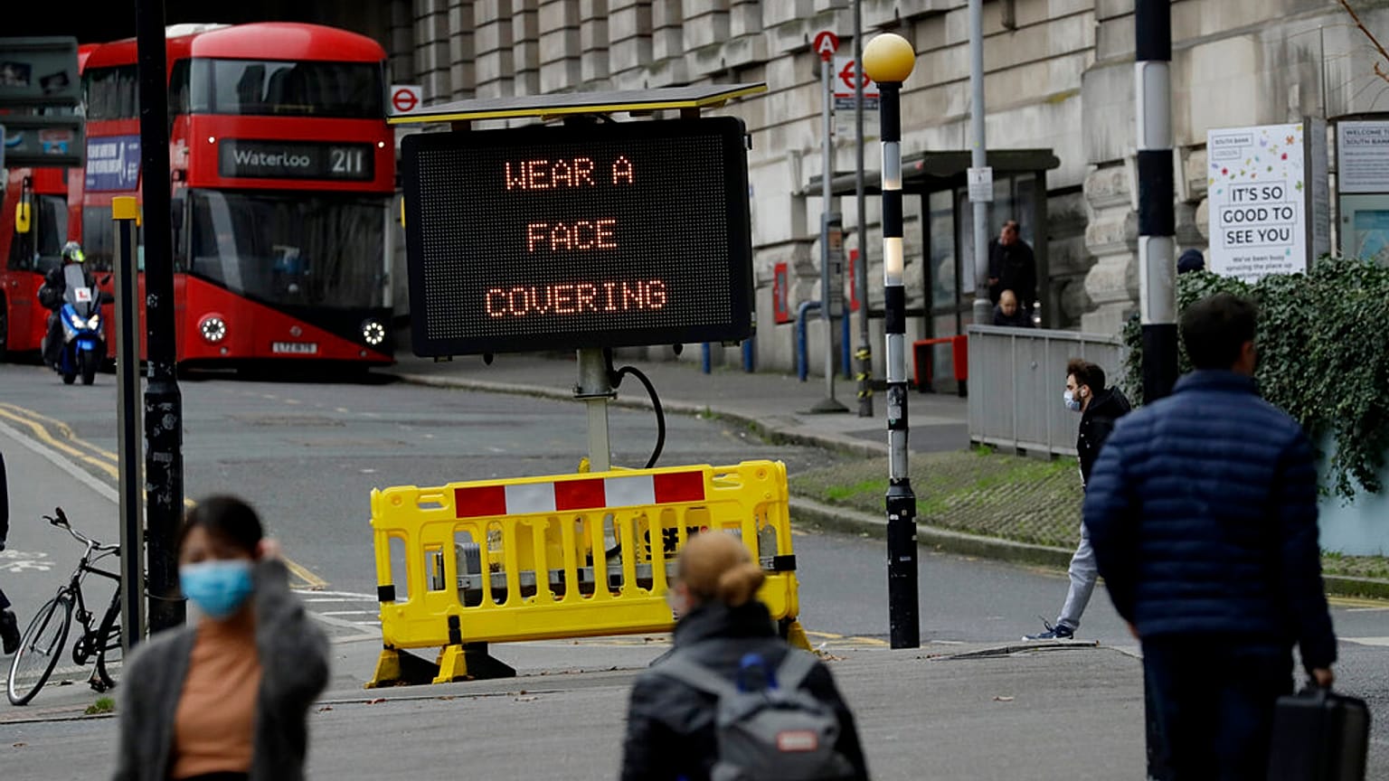A sign is displayed outside London's Waterloo train station to remind people thy are required to wear face coverings inside the station 