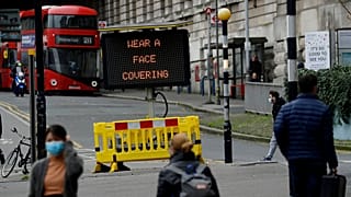 A sign is displayed outside London's Waterloo train station to remind people thy are required to wear face coverings inside the station 