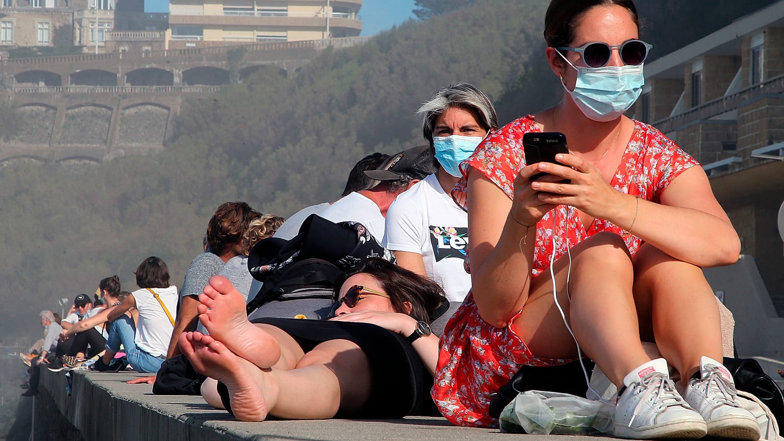 People sunbathe near the Atlantic ocean in Biarritz, southwestern France, Sunday, Nov. 1, 2020.