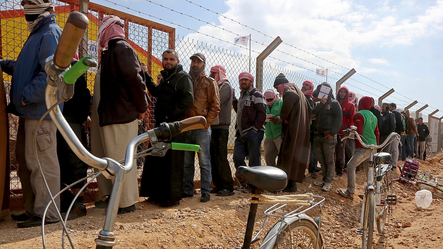 Syrian refugees line up to register their names at an employment office, at the Azraq Refugee Camp in Jordan.