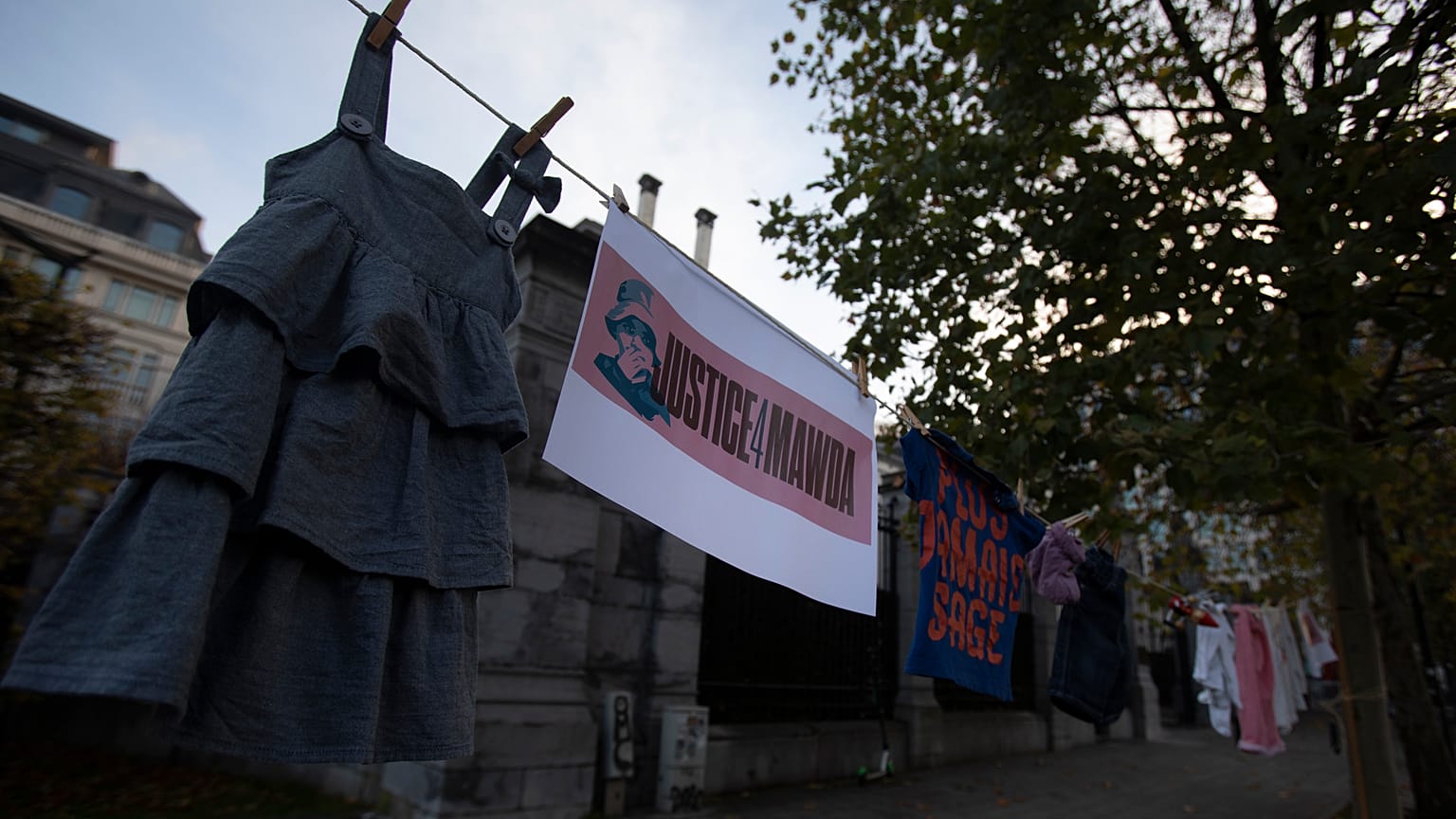 Several people hung children's clothing outside the courthouse, alongside banners reading "Justice for Mawda".