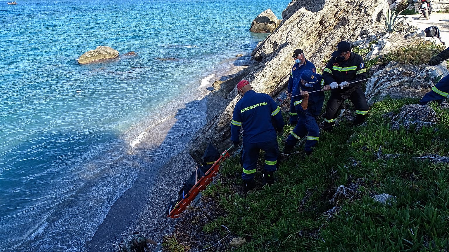 Firefighters retrieve the body of a migrant from the beach after the boat partially sank near the Greek island of Rhodes.