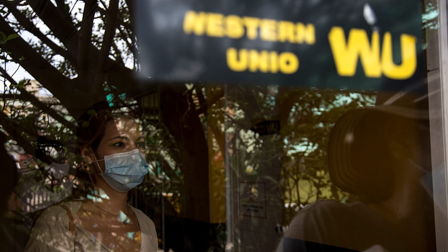 Una mujer espera para recoger dinero en una oficina de Western Union en su último día de actividad en La Habana, Cuba, el 23 de noviembre de 2020. 