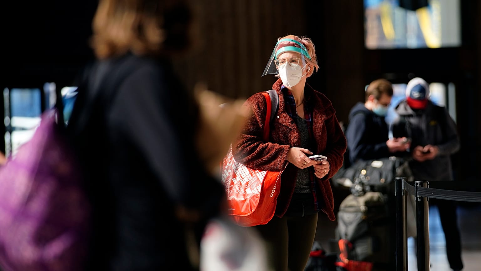 A woman waits in line for a train at the 30th Street Station ahead of the Thanksgiving holiday, Friday, Nov. 20, 2020, in Philadelphia. 