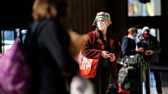A woman waits in line for a train at the 30th Street Station ahead of the Thanksgiving holiday, Friday, Nov. 20, 2020, in Philadelphia. 