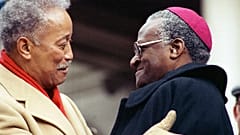  Mayor David Dinkins, left, gets a hug from South African Bishop Desmond Tutu
