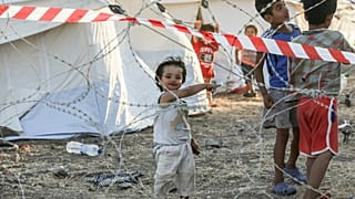 عائلات مهاجرة خلف أسلاك شائكة في منطقة الحجر الصحي في المخيم المؤقت الجديد بالقرب من ميتيليني في جزيرة ليسبوس اليونانية